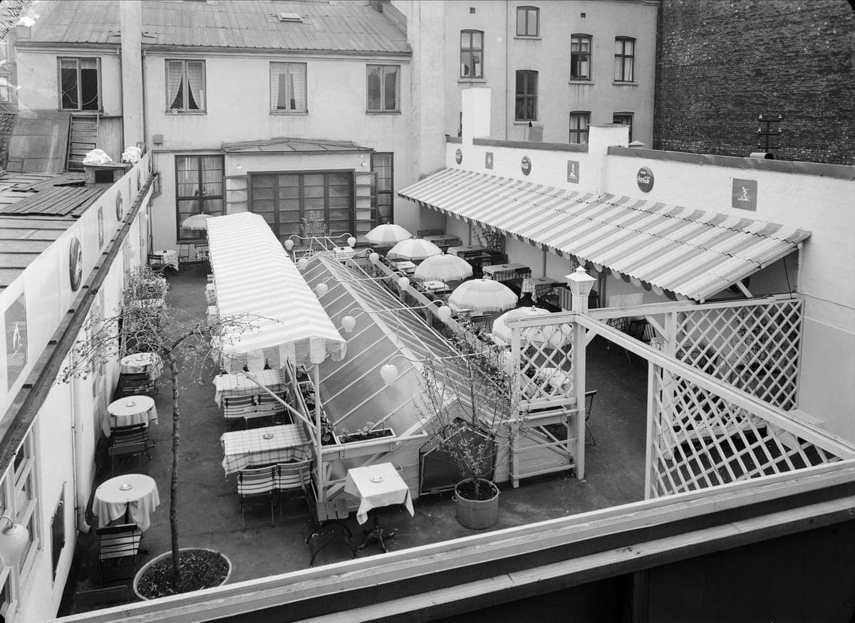 Archival photo of Olympen's courtyard terrace with striped awnings