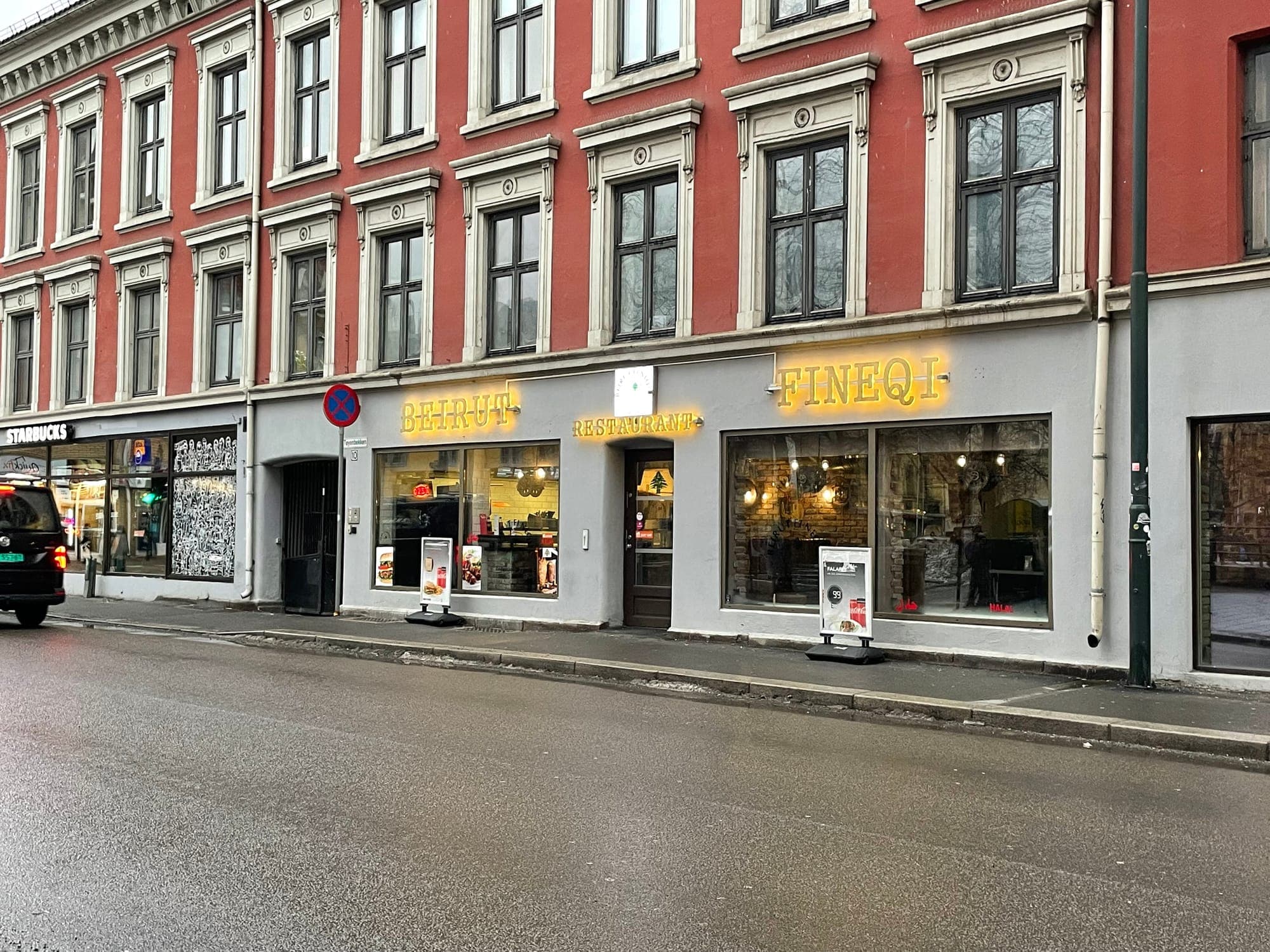 Feniqia's gold lettering over a glass shopfront on a rainy street