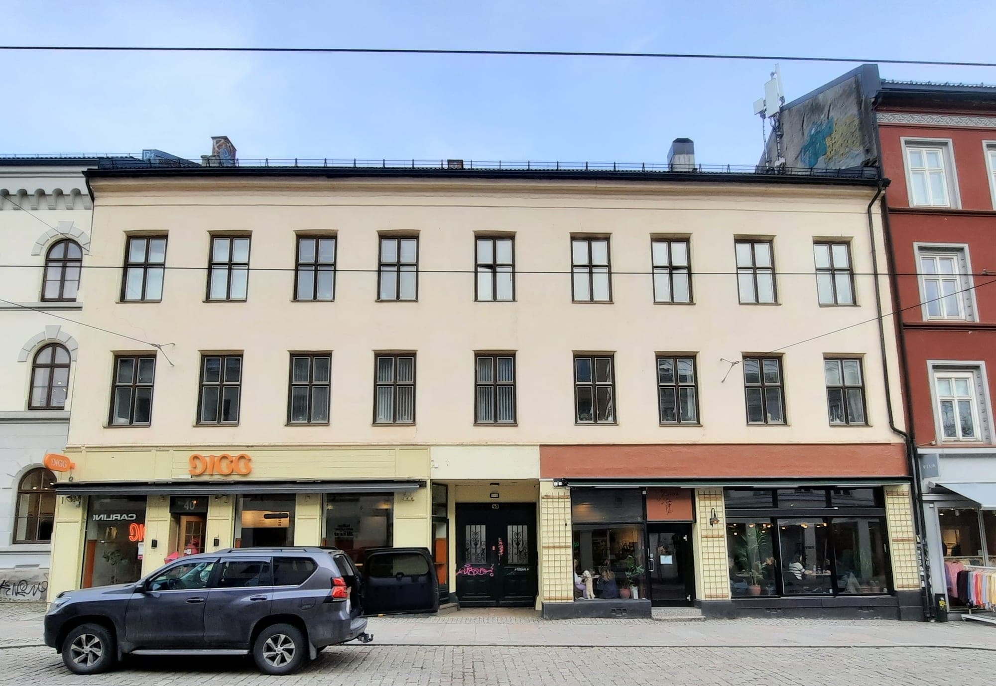 Cream three-storey block with small street-level shopfronts