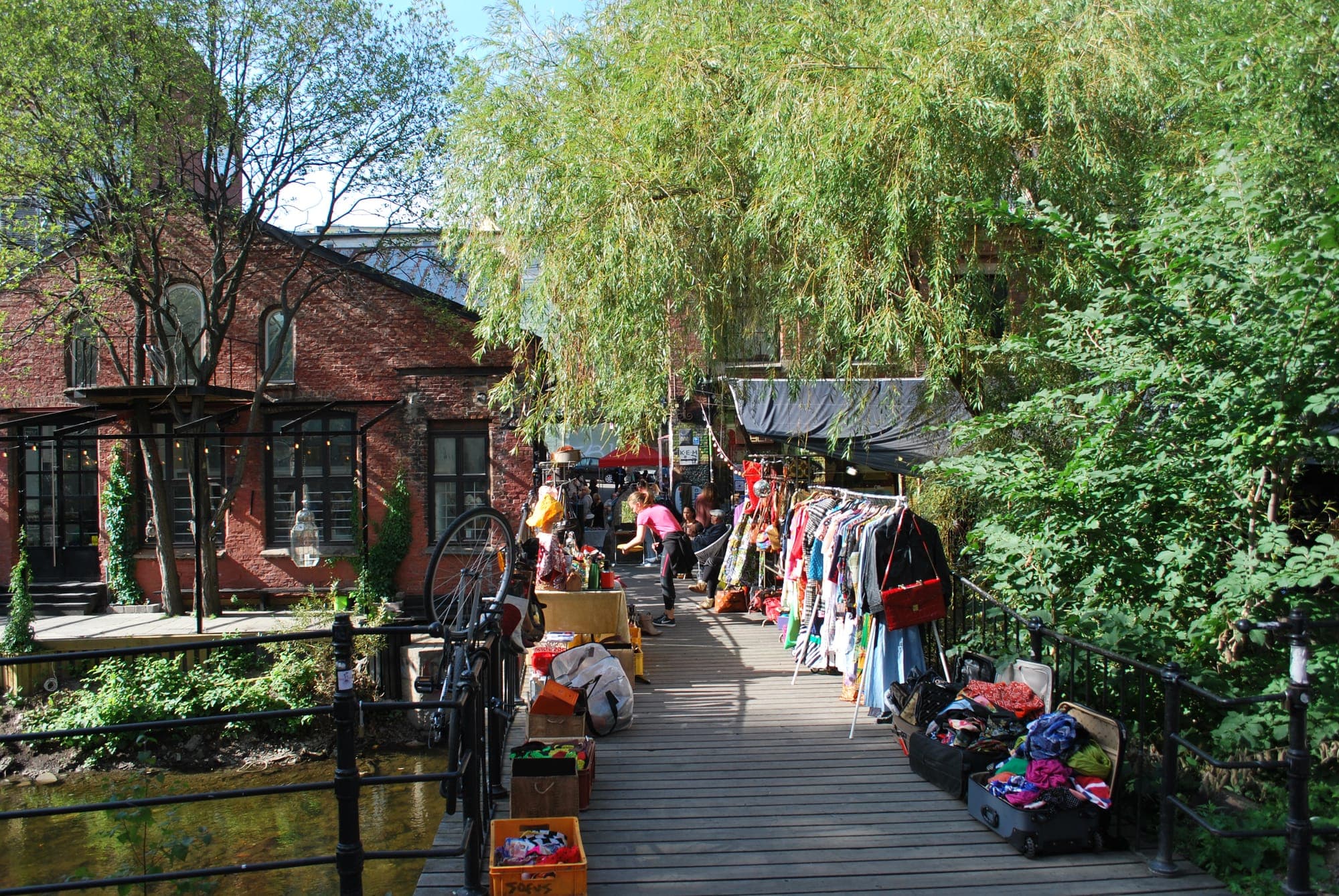 Market stalls and clothing racks on Blå's riverside boardwalk