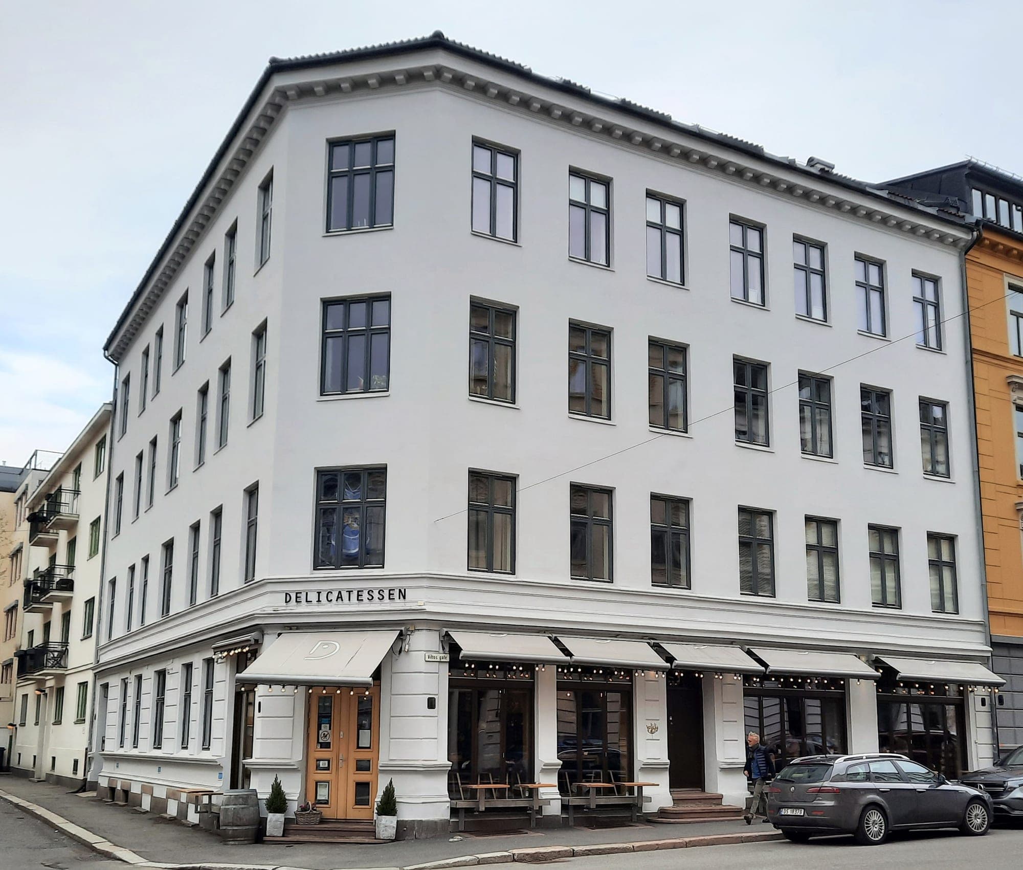 White corner building with Delicatessen lettering over black awnings