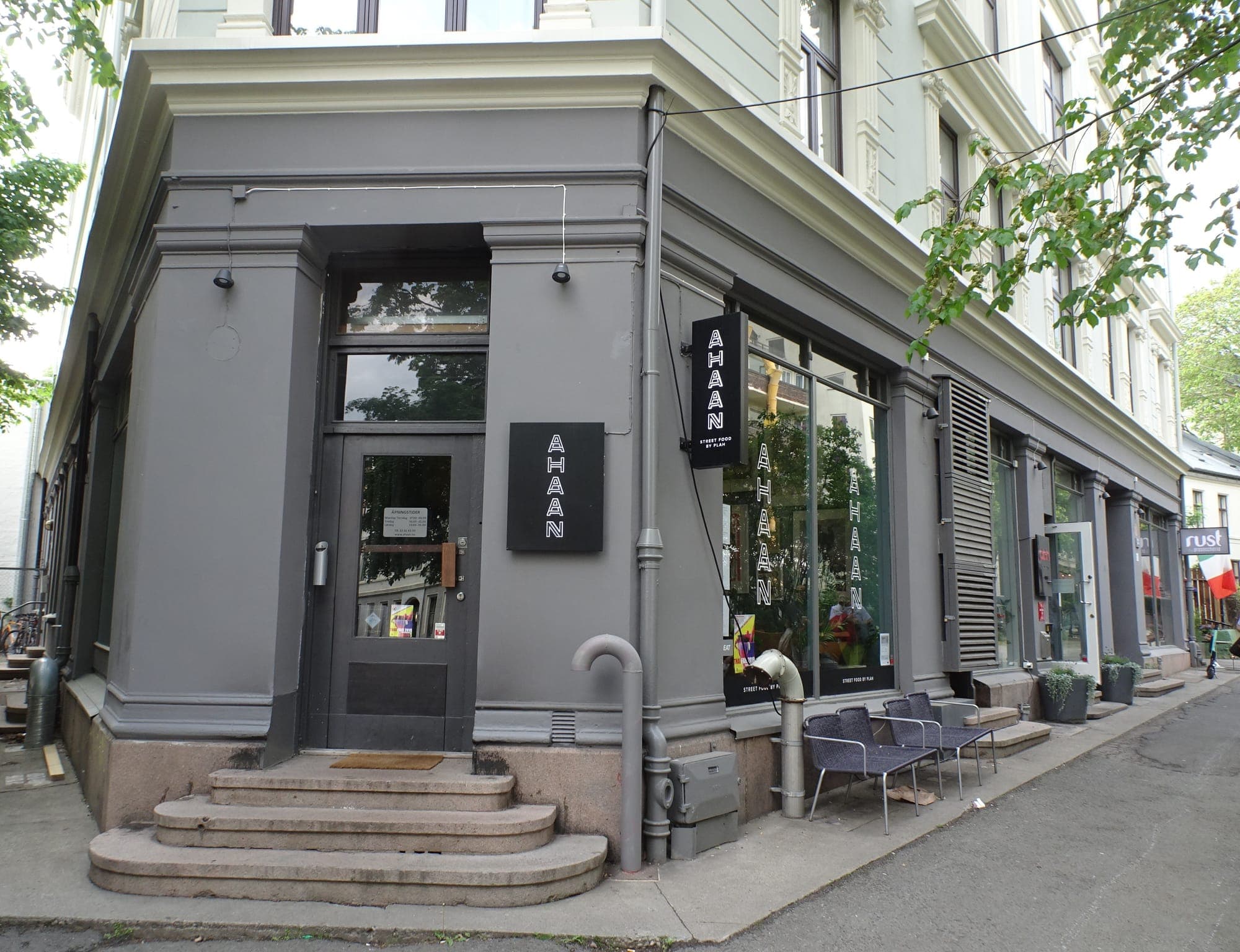 Ahaan's grey corner storefront with stone steps and hanging sign